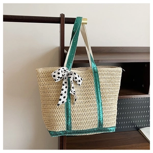 Détail d'un sac en paille avec paillettes vertes et foulard à pois sur support bois