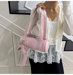 Pink Boston bag with retro matte leather and large bow pendant accessory shown on model