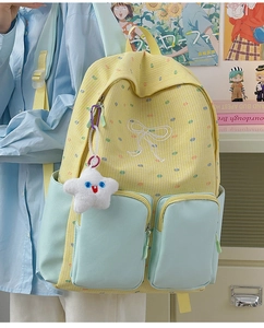Detailed view of yellow plaid school backpack with mint green pockets and star pendant