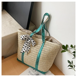 Détail du sac cabas en paille avec paillettes vertes et nœud à pois noir et blanc