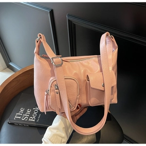 Detail of light pink dumpling bag with multiple zipper pockets and glossy wrinkled finish