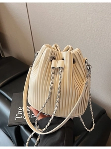 Elegant beige pleated bucket bag with chain drawstring and premium faux leather finish