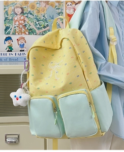 Detailed side view of yellow checkered backpack with bow embroidery and star charm