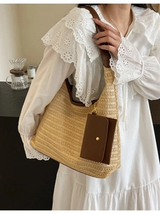 Handmade woven straw tote bag with brown leather straps and a matching small pouch