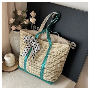 Détail d'un sac cabas en paille avec des paillettes vertes et un nœud à pois élégant