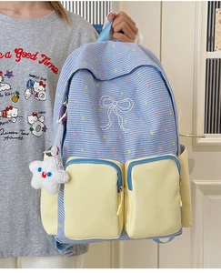 Detail of blue and white checkered backpack with yellow pockets and star charm