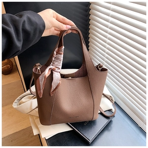 Detail of vintage brown pebble leather bucket bag with pink heart silk scarf handle
