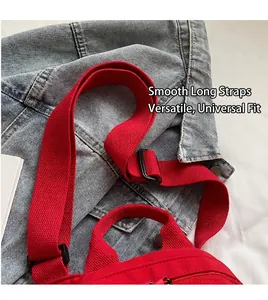 Detail of red canvas bag showing adjustable shoulder strap with black buckle and durable zipper