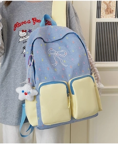 Detailed view of blue plaid backpack with yellow pockets and star plush charm accessory