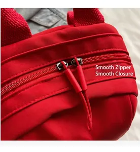 Detail of red backpack dual zippers with durable non-slip pull cords and smooth closure