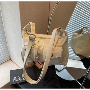 Detail view of beige faux leather dumpling bag with cargo pockets and silver hardware