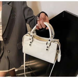 Details der weißen Handtasche aus Faltenleder mit Vintage-Nieten und Doppelgriffen