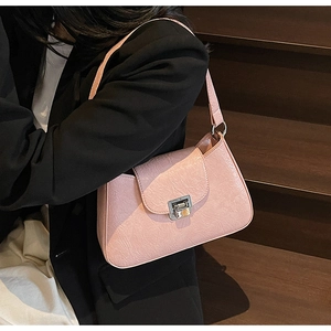 Pink rectangular underarm bag with crinkle texture and silver buckle shown on black blazer