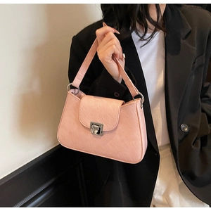 Polished pink shoulder bag with metallic buckle shown in a professional lifestyle shot