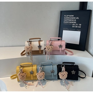 Detail of five multi-colored crossbody bags with star buckles and plush bear charms