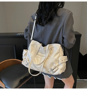 Detail of cream large tote bag with silver buckles and zippers on model back