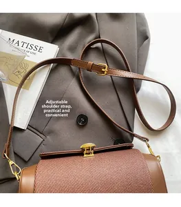 Detail of adjustable leather strap with gold buckle on contrast stitch crossbody bag