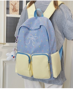 Detail view of preppy plaid backpack showing embroidery, star pendant and zip pockets