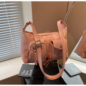 Pink matte leather hobo bag featuring utility pockets and adjustable shoulder strap