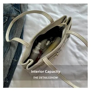Top view of cream white shoulder bag showing spacious interior with cosmetic bottles