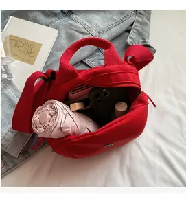 Detailed view showing large capacity of the red canvas shell bag with various essentials