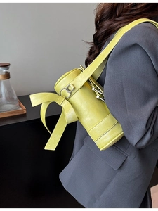 Fashionable lemon yellow Boston barrel bag with oversized bow and silver hardware links