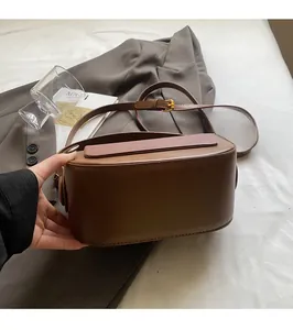 Detail of the brown leather saddle bag with textured flap and vintage gold buckle hardware