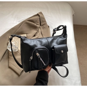 Detail of vintage black leather bag with silver metal buckle and multiple utility pockets