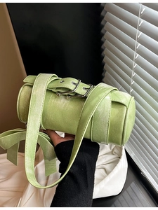Pale green cylindrical Boston pillow bag with wide strap and metallic buckle detail