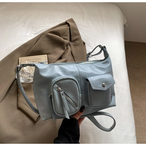 Detail of light blue vintage hobo bag showing zip and magnetic flap front pockets