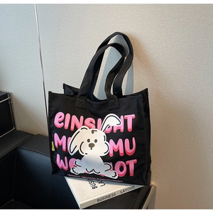 Close-up of black canvas tote bag with pink rabbit print and artistic letters