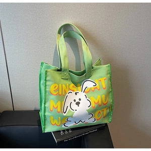 Detail of green canvas tote bag featuring a cartoon rabbit and orange typography design