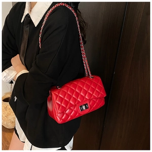 Detail of red quilted patent leather bag with silver chain strap and twist lock closure