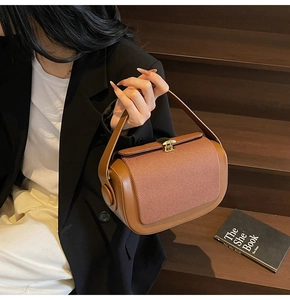 Detail of a brown patchwork pillow bag featuring leather and striped fabric textures