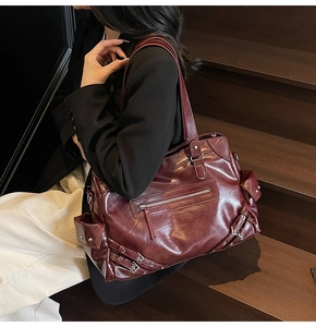 Detail of burgundy glossy faux leather tote bag with vintage silver metal zippers
