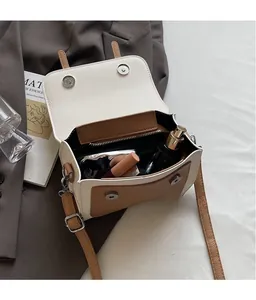Detail view of contrast color crossbody bag showing interior storage and magnetic flap