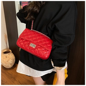 Close-up of red quilted chain bag featuring silver rectangular metal twist lock buckle