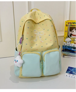 Detailed close-up of yellow plaid backpack with blue pockets and white bow embroidery