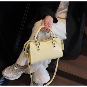 Nahaufnahme der beigen Lackledertasche mit Vintage-Nieten und abnehmbarem Schultergurt