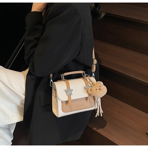Détail du sac à bandoulière bicolore avec étoiles argentées et breloque ours en peluche