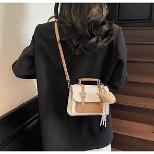 Détail du sac à main carré bicolore avec étoiles argentées et pendentif d'ours en peluche