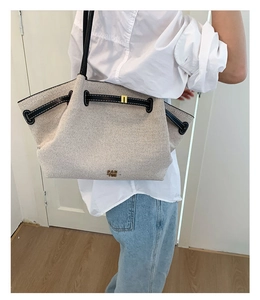 Detalle del bolso tote de lona que muestra la textura gruesa y los acabados en cuero negro