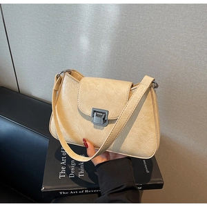 Detail of beige pleated faux leather underarm bag with a vintage metal magnetic clasp