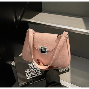 Detail of light pink shoulder bag with pleated texture and silver rectangular metal clasp