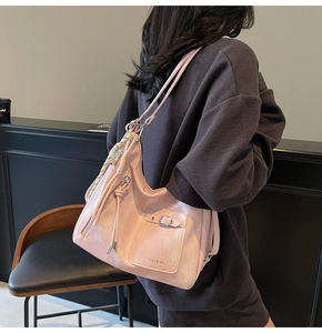 Detail of pink large-capacity hobo bag with fringe tassels and functional front pocket