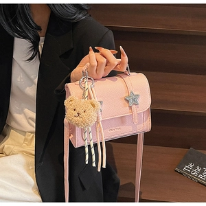 Sac à main en cuir rose grainé avec détail d'étoile métallique et pendentif ours peluche
