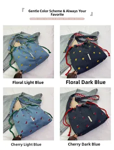 Detail view of denim bucket bag with floral embroidery and adjustable strap