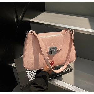 Close-up of pink crinkled leather underarm bag featuring a silver metal push-lock closure