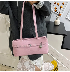 Detail view of pink Y2K shoulder bag with silver heart charm and belt buckle accents