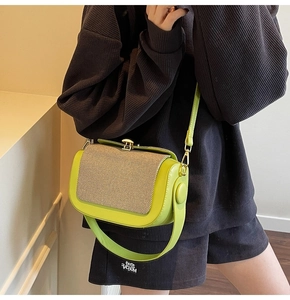 Detail of neon green leather pillow bag with textured fabric flap and gold metal buckles